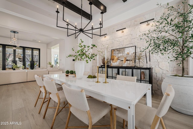 dining area with beamed ceiling and light wood-type flooring