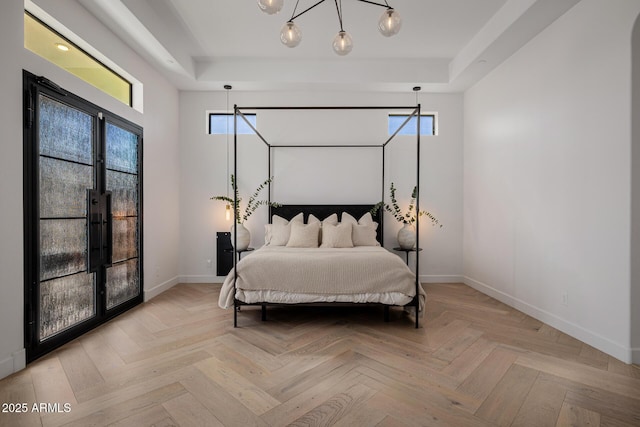 bedroom with light parquet flooring and a raised ceiling