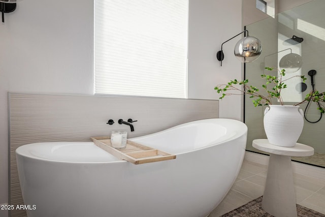 bathroom with a bath and tile patterned flooring