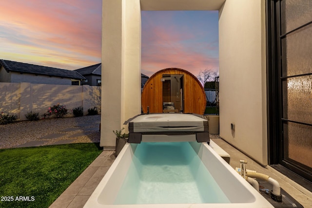 patio terrace at dusk with a hot tub