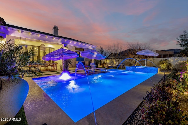 pool at dusk with pool water feature