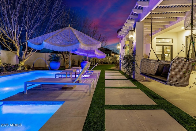 pool at dusk featuring a pergola and a patio area