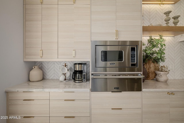 kitchen featuring tasteful backsplash, light brown cabinetry, and light stone countertops