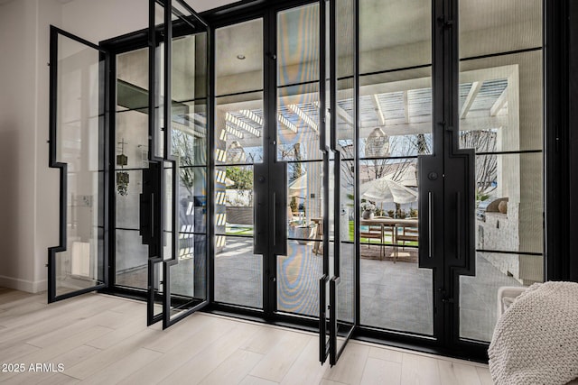 doorway with hardwood / wood-style flooring and floor to ceiling windows