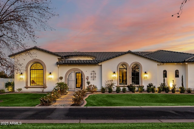 mediterranean / spanish-style house with a yard