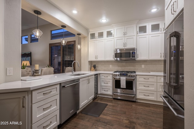 kitchen featuring white cabinetry, appliances with stainless steel finishes, kitchen peninsula, and sink