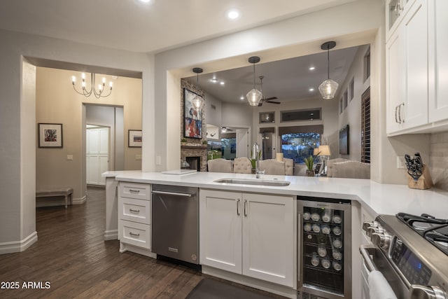 kitchen with white cabinetry, sink, beverage cooler, and kitchen peninsula