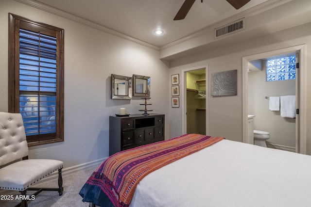 bedroom with crown molding, a spacious closet, ensuite bathroom, and ceiling fan