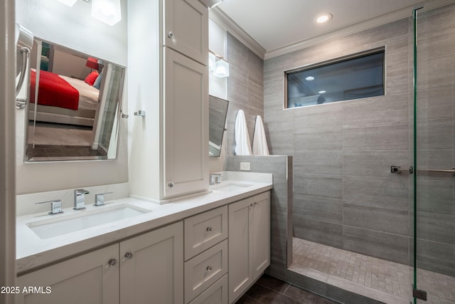 bathroom featuring tiled shower, vanity, tile patterned flooring, and ornamental molding