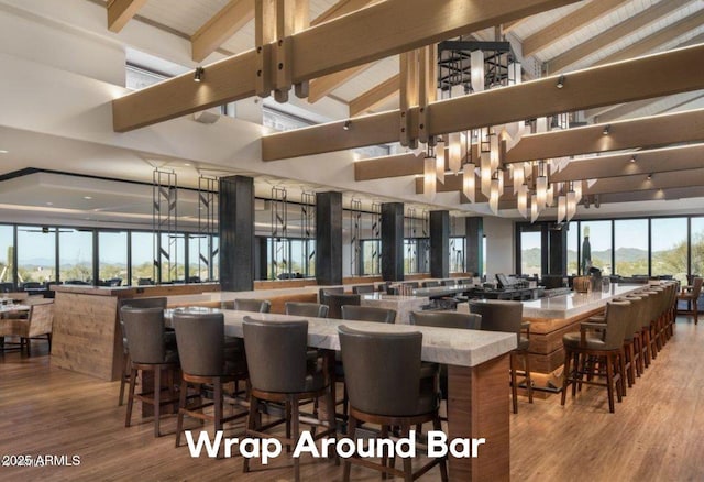 dining area with beam ceiling, high vaulted ceiling, hardwood / wood-style floors, and a notable chandelier