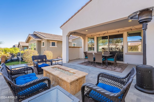 view of patio with an outdoor living space with a fire pit