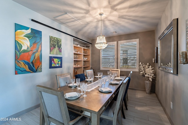 dining room with light hardwood / wood-style flooring and a notable chandelier