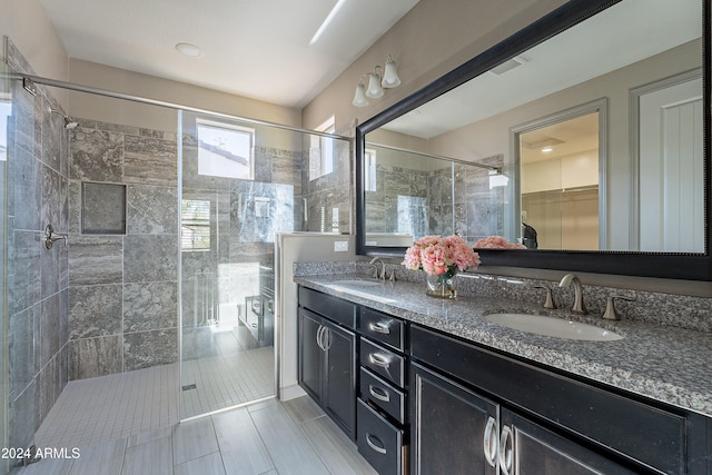 bathroom with tile patterned flooring, vanity, and walk in shower