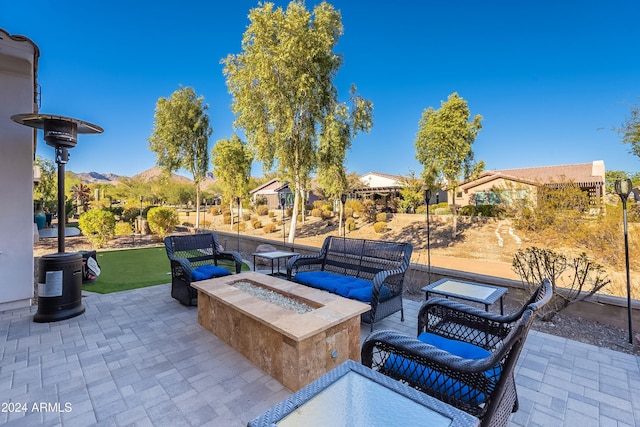 view of patio / terrace with a mountain view and an outdoor living space with a fire pit