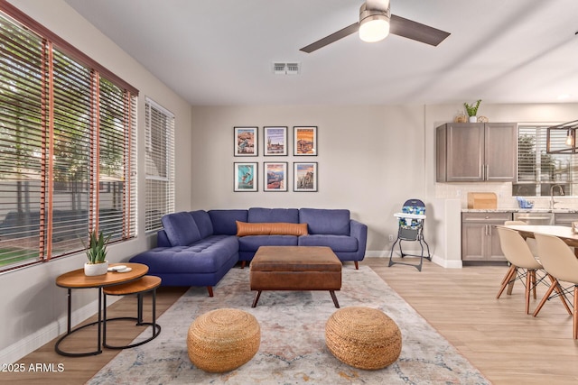 139 E Gail Dr, Gilbert, AZ 85296 - living room with light wood finished floors, a ceiling fan, and baseboards