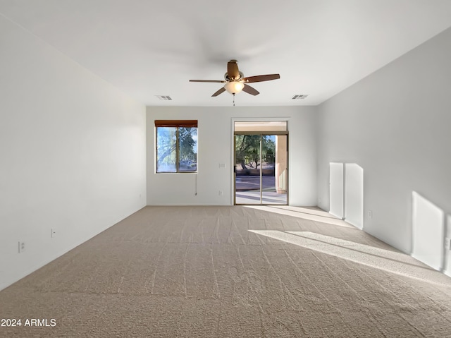 carpeted spare room featuring ceiling fan