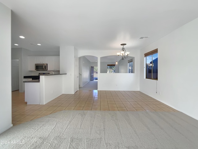 interior space with a notable chandelier, a healthy amount of sunlight, and light tile patterned flooring