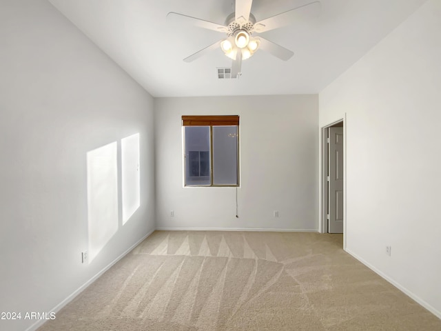 empty room featuring ceiling fan and light colored carpet