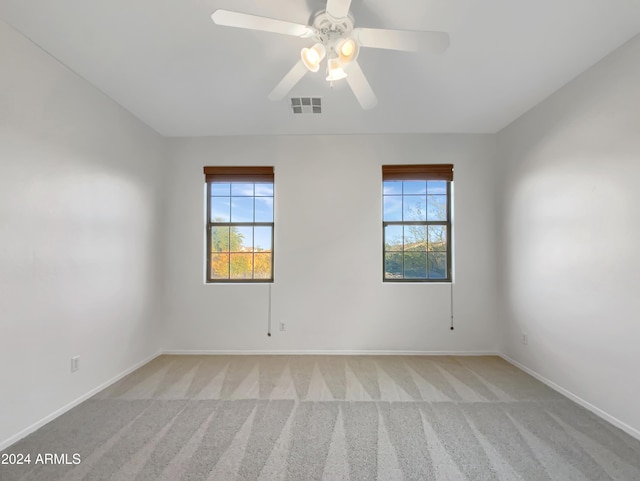 carpeted empty room featuring ceiling fan and a wealth of natural light