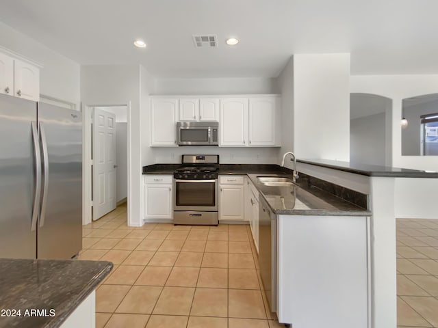 kitchen featuring kitchen peninsula, appliances with stainless steel finishes, sink, white cabinetry, and light tile patterned flooring