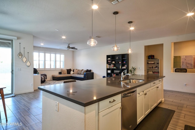 2727 N Acacia Way, Buckeye, AZ 85396 - kitchen with a sink, stainless steel dishwasher, dark countertops, open floor plan, and white cabinetry