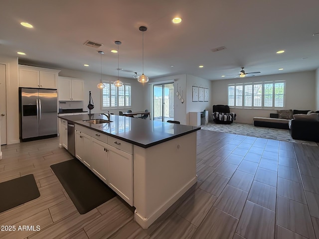 2727 N Acacia Way, Buckeye, AZ 85396 - kitchen with stainless steel appliances, a sink, dark countertops, plenty of natural light, and recessed lighting