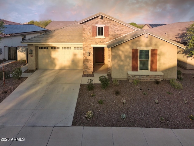 2727 N Acacia Way, Buckeye, AZ 85396 - traditional home with an attached garage, stone siding, driveway, and stucco siding