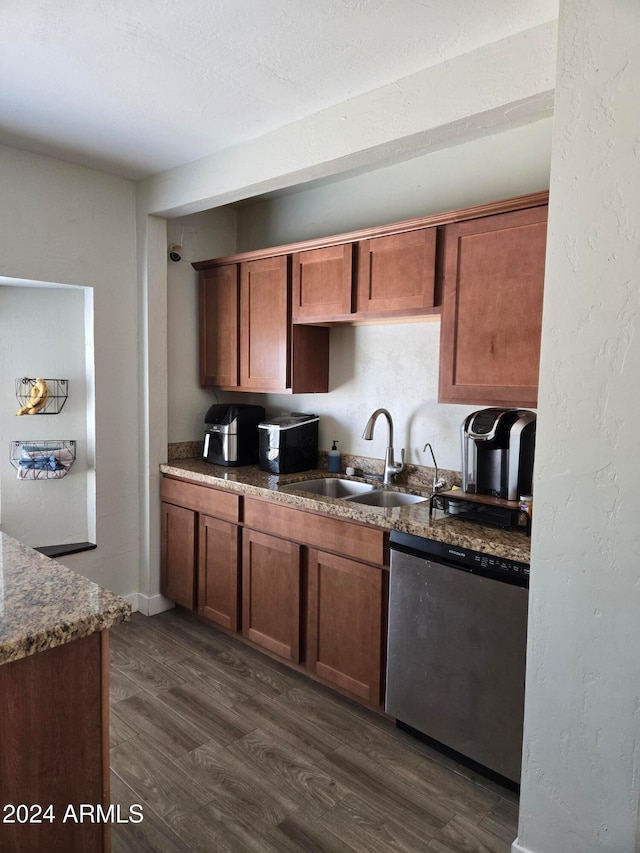 kitchen with dark hardwood / wood-style flooring, stainless steel dishwasher, and sink