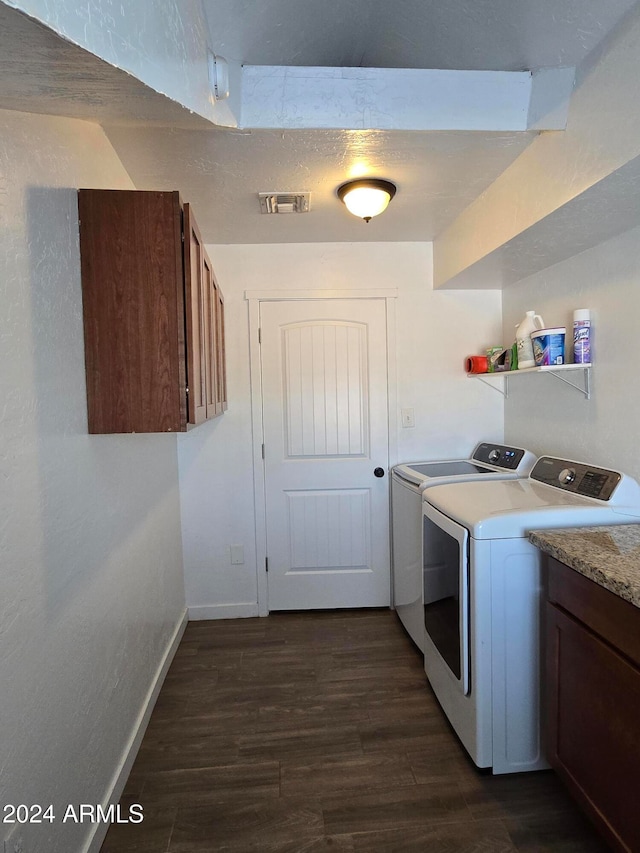 washroom with cabinets, washing machine and dryer, and dark hardwood / wood-style floors