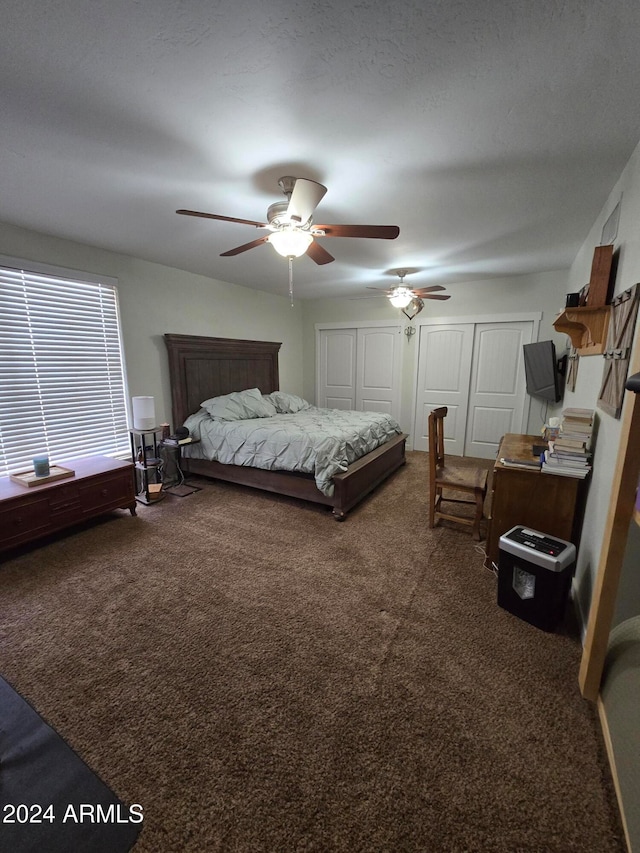 bedroom with a textured ceiling, ceiling fan, and dark carpet