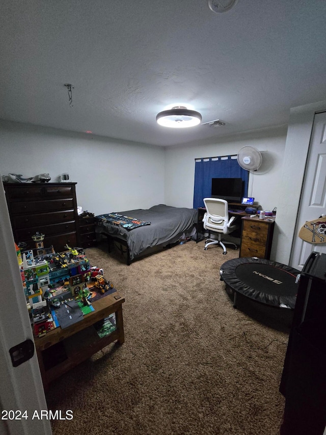 bedroom featuring carpet and a textured ceiling