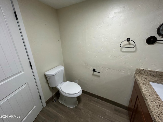 bathroom featuring wood-type flooring, vanity, and toilet