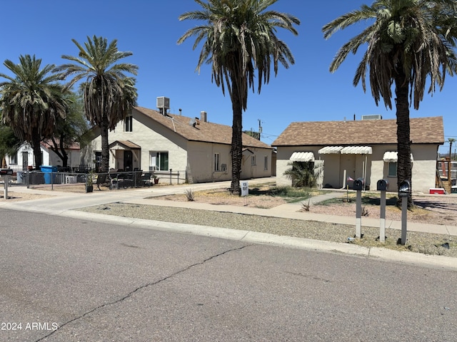 view of front facade featuring fence, central AC, and stucco siding