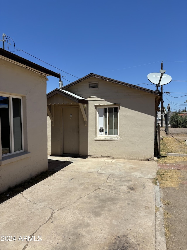 view of side of property with a patio and stucco siding