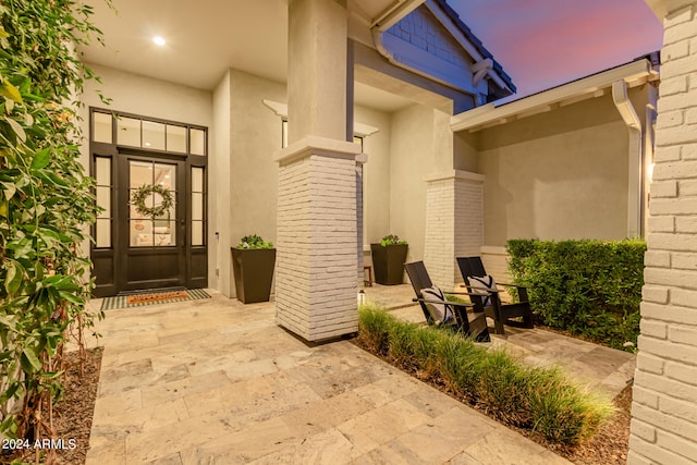 exterior entry at dusk with a patio area