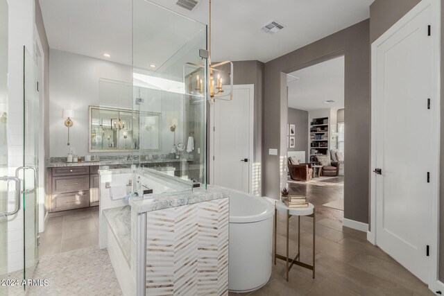 bathroom with a chandelier, shower with separate bathtub, vanity, and tile patterned floors