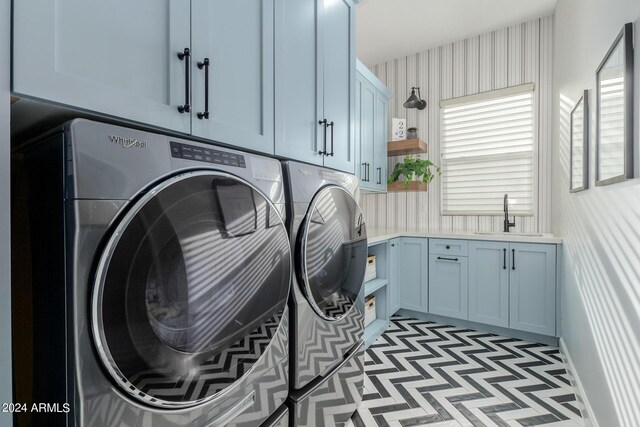 laundry room featuring cabinets, washer and clothes dryer, and sink