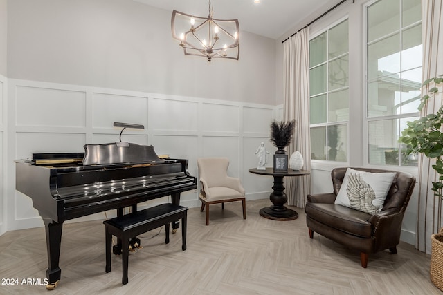 sitting room with light parquet floors and a notable chandelier