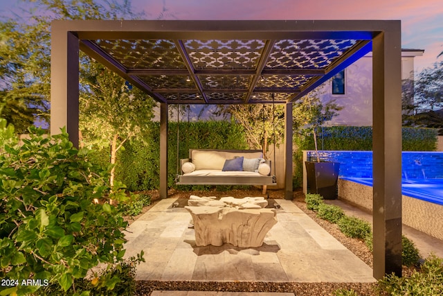 patio terrace at dusk featuring a pergola and a swimming pool