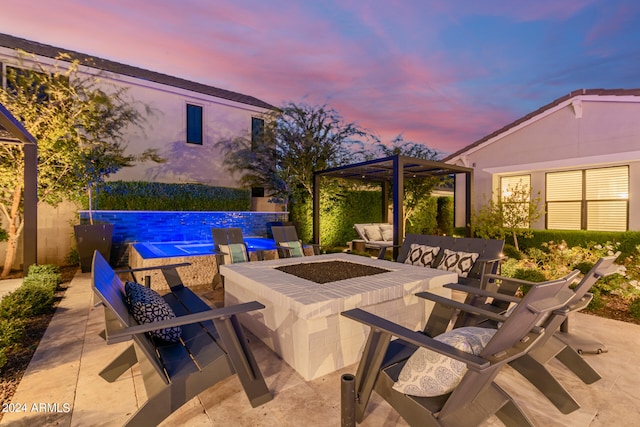 patio terrace at dusk featuring an outdoor living space with a fire pit