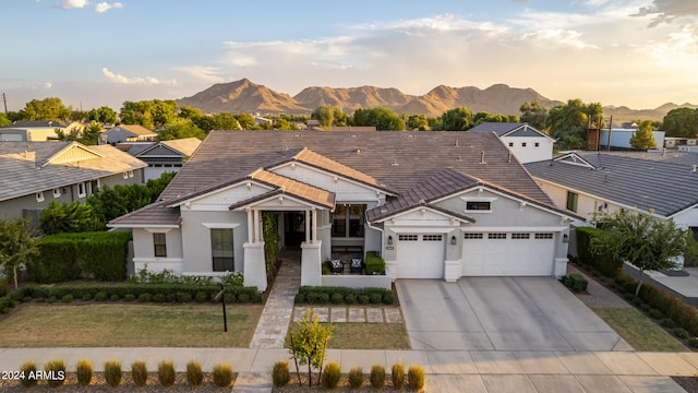 view of front facade featuring a mountain view, a yard, and a garage