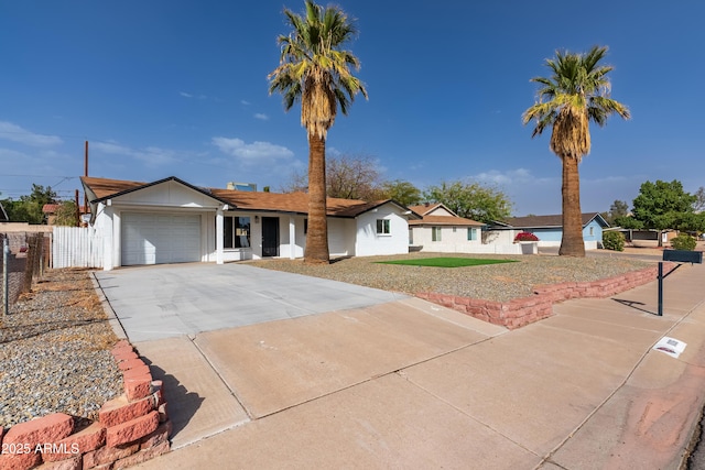 ranch-style house with a garage, fence, and concrete driveway