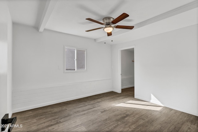 empty room featuring ceiling fan, beamed ceiling, wood finished floors, and baseboards