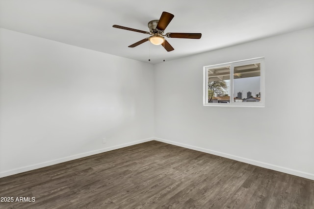 unfurnished room with ceiling fan, dark wood-style flooring, and baseboards