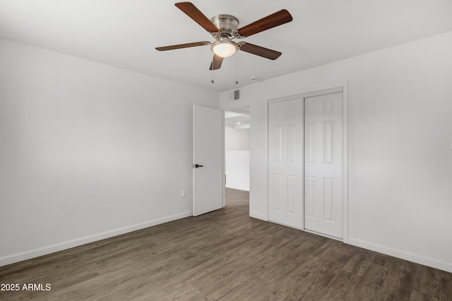 unfurnished bedroom featuring baseboards, visible vents, ceiling fan, wood finished floors, and a closet