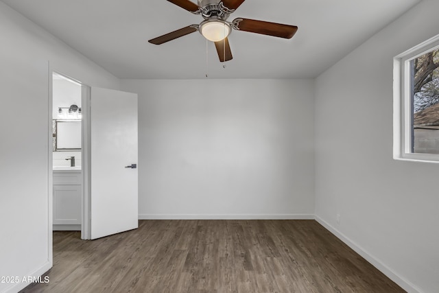 spare room with ceiling fan, baseboards, and wood finished floors