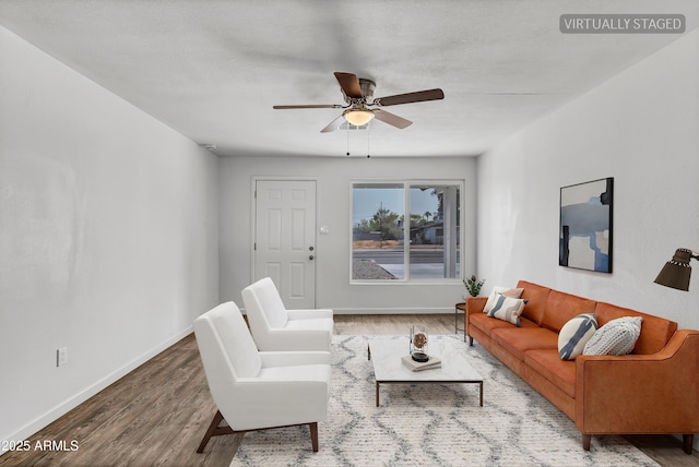 living room featuring ceiling fan, wood finished floors, and baseboards