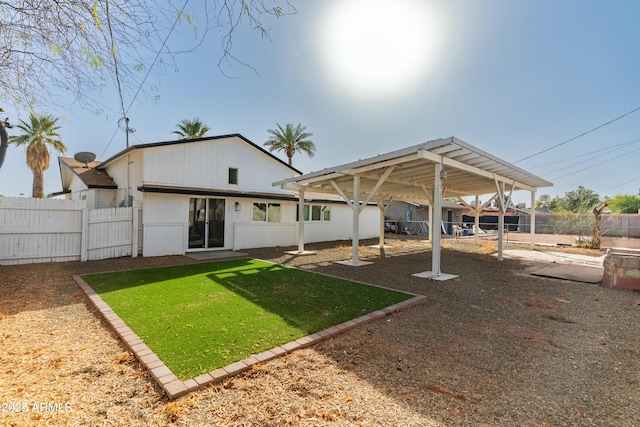 back of house featuring fence and a yard