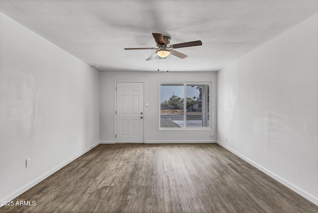 spare room with ceiling fan, wood finished floors, and baseboards