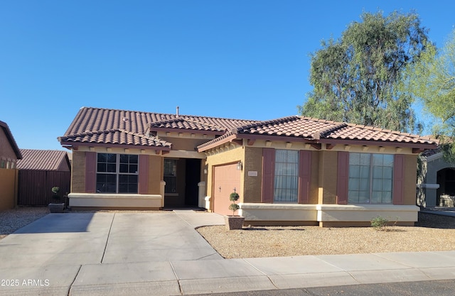 view of front of home with a garage, stucco siding, a tile roof, and concrete driveway
